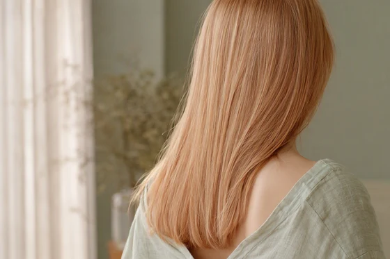 Fine straight strawberry blonde hair with a soft pink-copper cast, photographed from behind